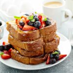 French toast topped with fresh berries and mint.