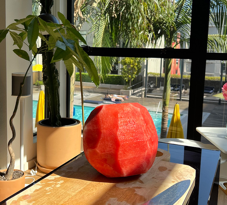 A whole watermelon on a cutting board.