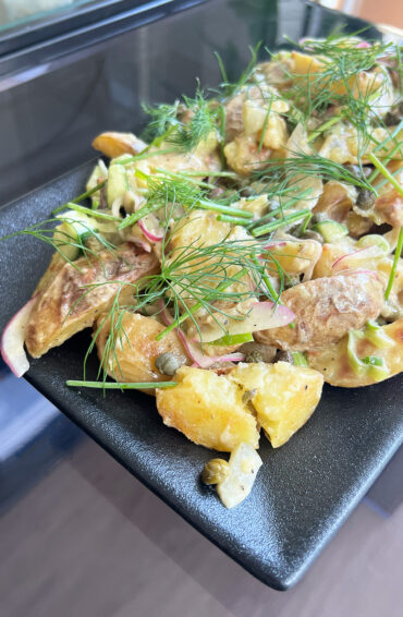 Herby Roasted Potato Salad plated on a serving dish.