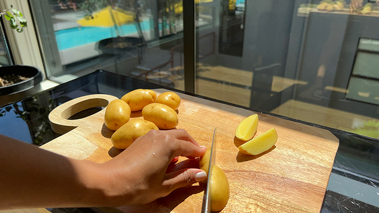 Sliced Yukon Gold Potatoes on a cutting board.