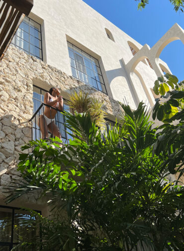 Woman standing on the balcony of an Airbnb in Tulum.