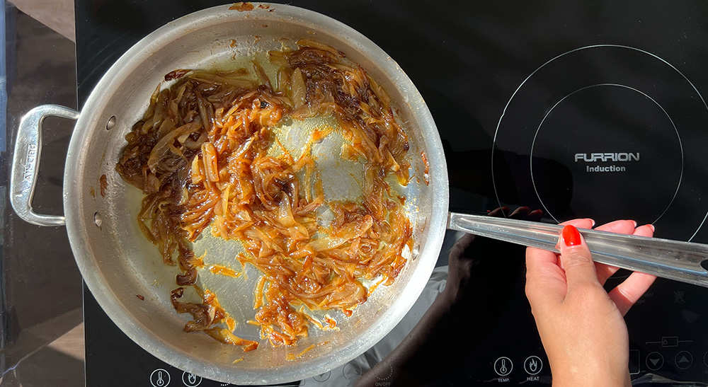 Caramelized onions sauteeing in a pan.